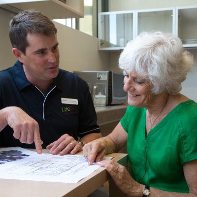 occupational therapist reviewing floor plan for home modification with an elderly woman